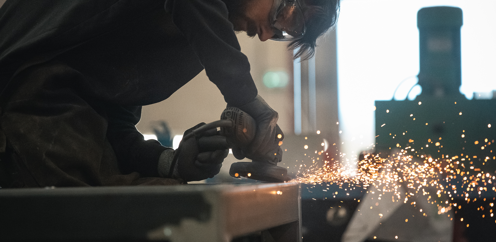 employé sogire qui scie le métal